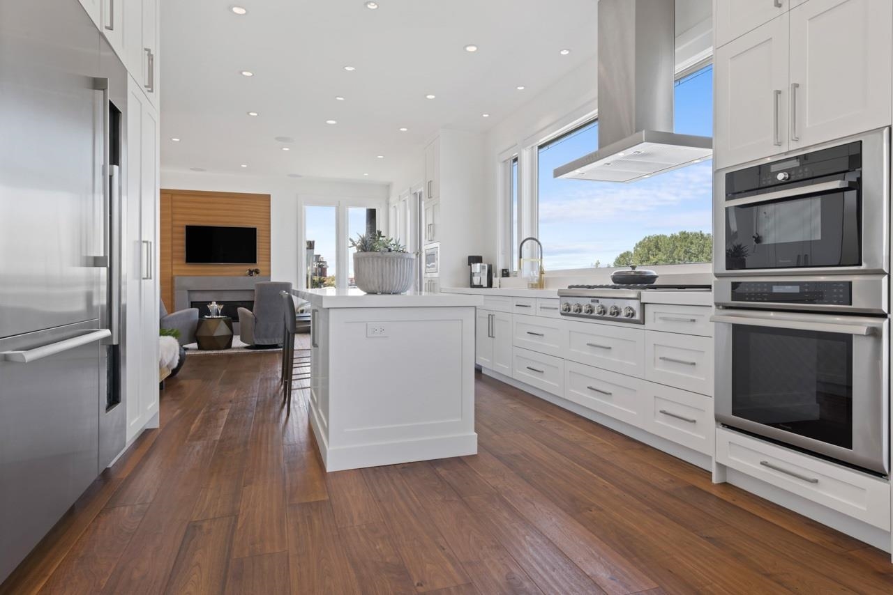 Quartz counters and white cabinetry with stainless appliances.  Expansive glass brings in the view of boats passing or wildlife on the water.