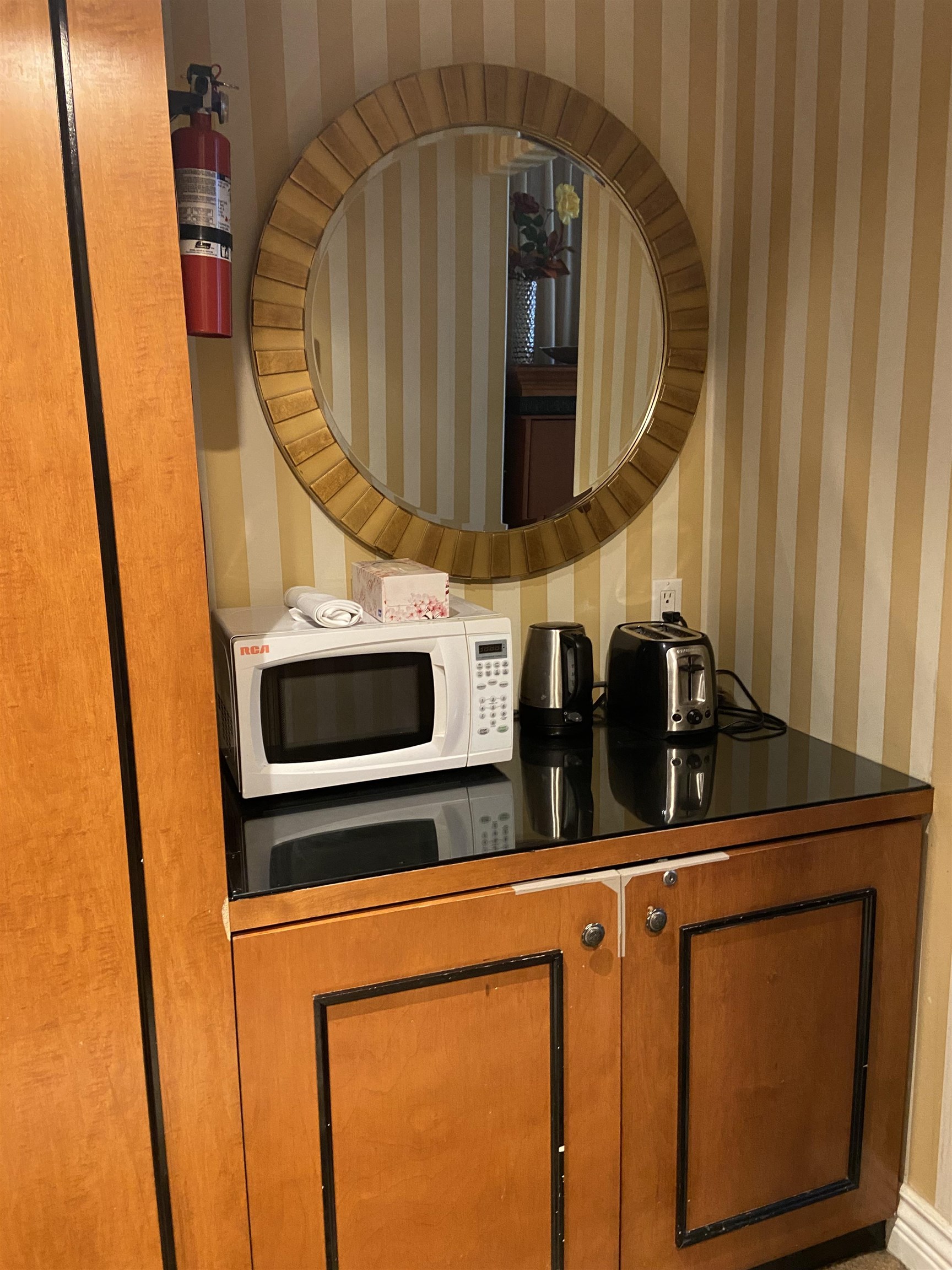 Cabinet with microwave, kettle, toaster and bar fridge.