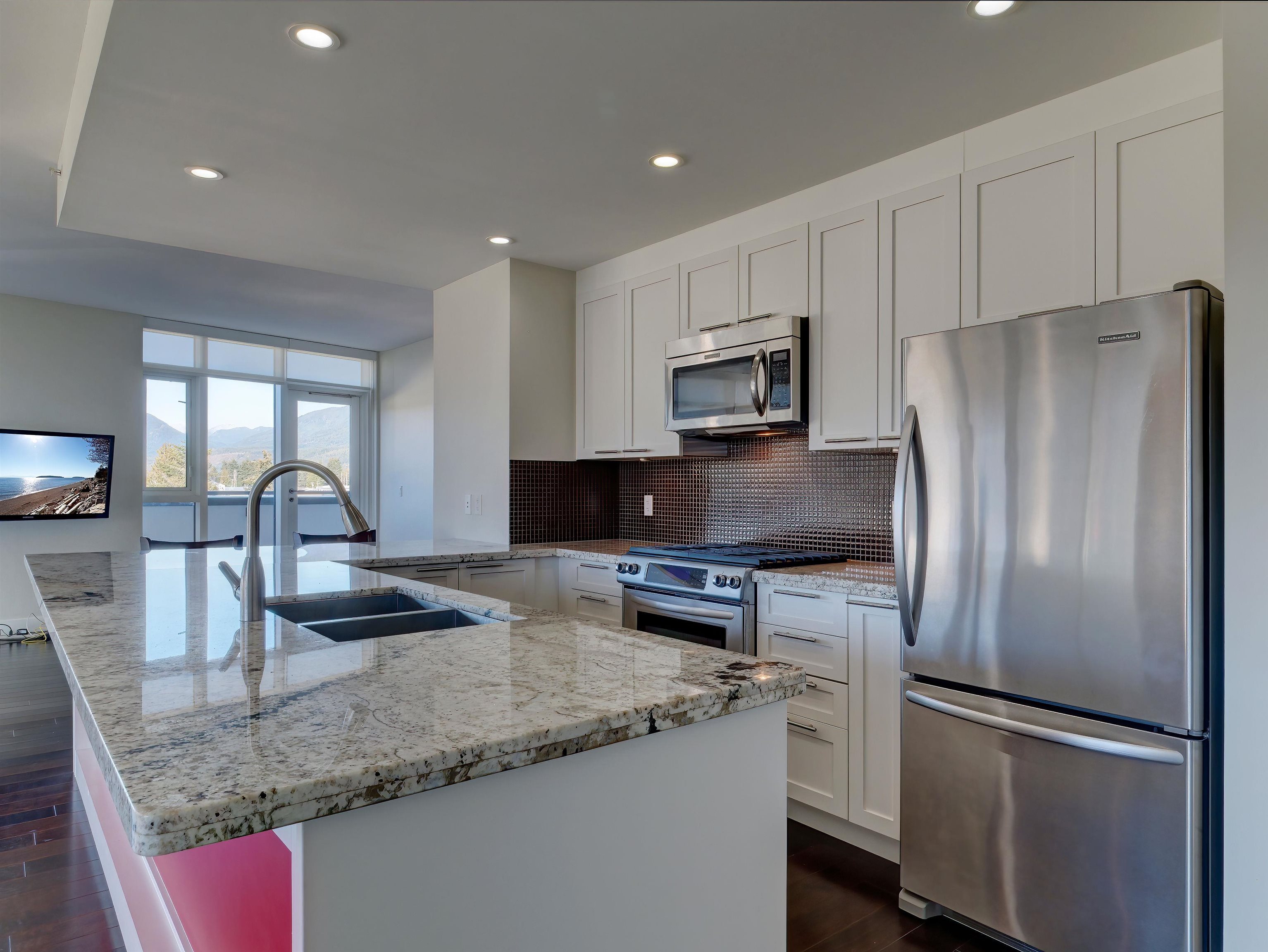 Granite counter, modern stainless appliances. You'll always be in the conversation in this spacious open floor plan, while guests cozy up to the wrap-around sit up bar which would comfortably seat six people. Great for entertaining.
