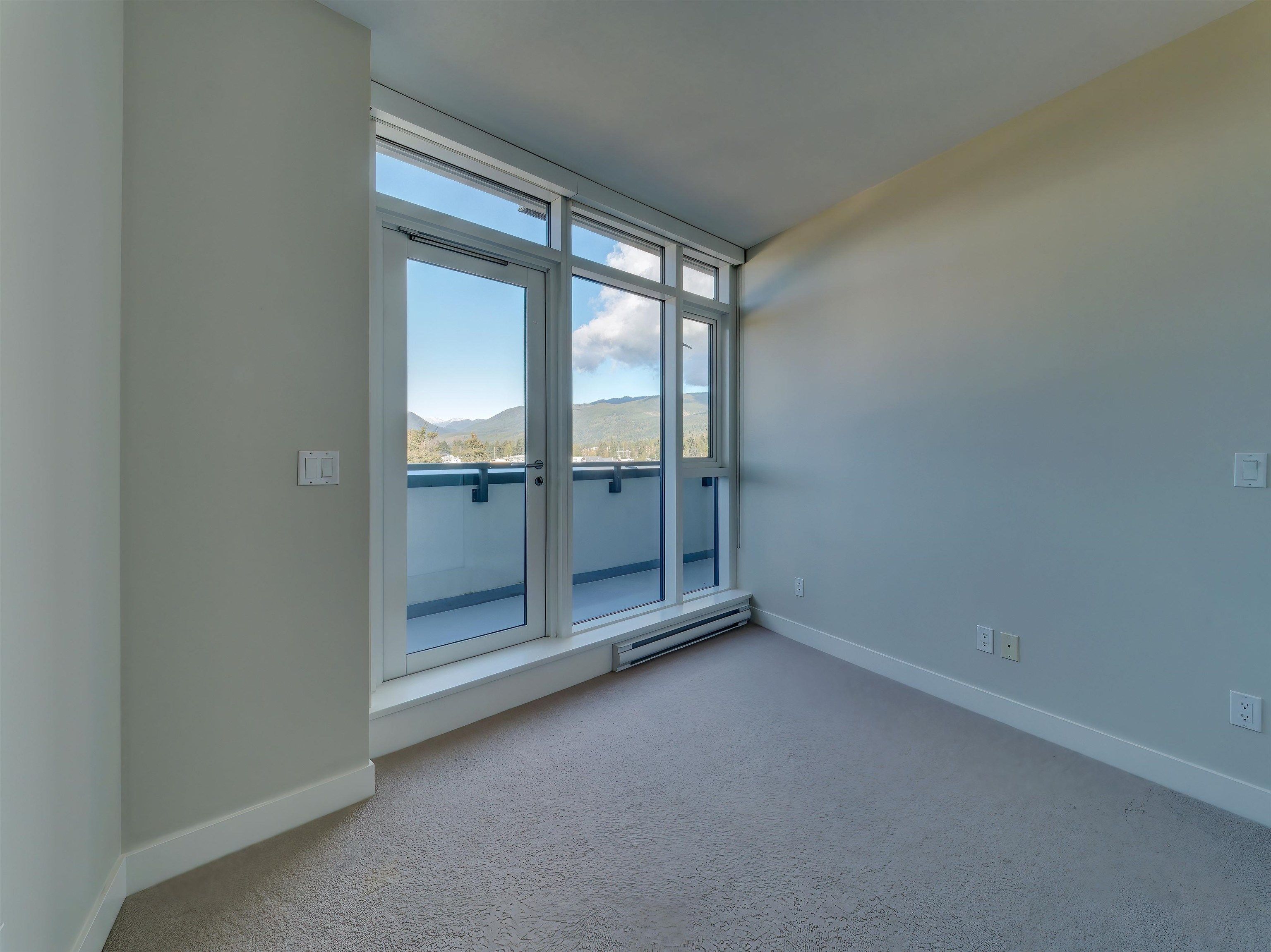 The perfect sized guest bedroom has deck access through slider doors and mountain views.