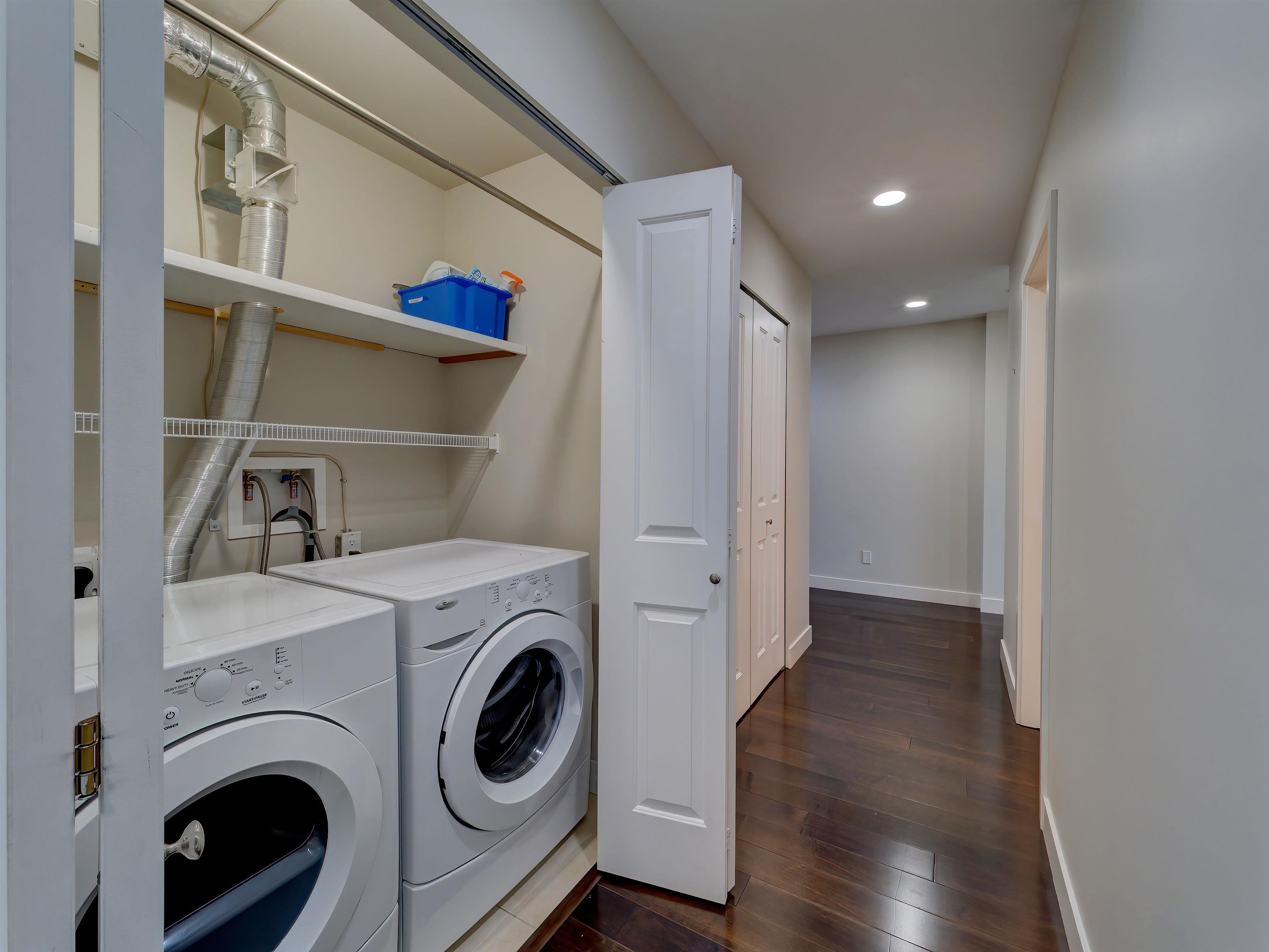The laundry closet is located nicely away from the main living area and offers plenty of shelving and bi-fold doors.