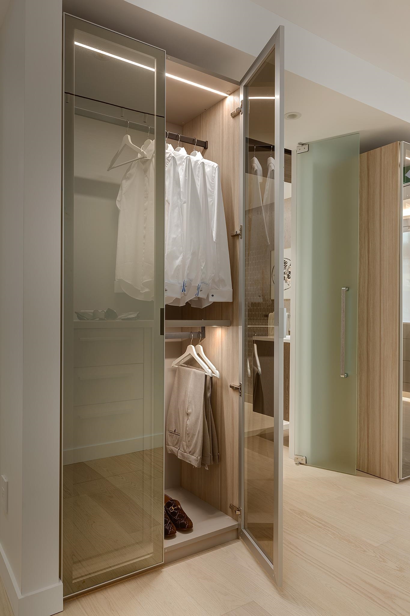 Sample of Primary Bedroom glass door closets with built-in shelving and drawer system.